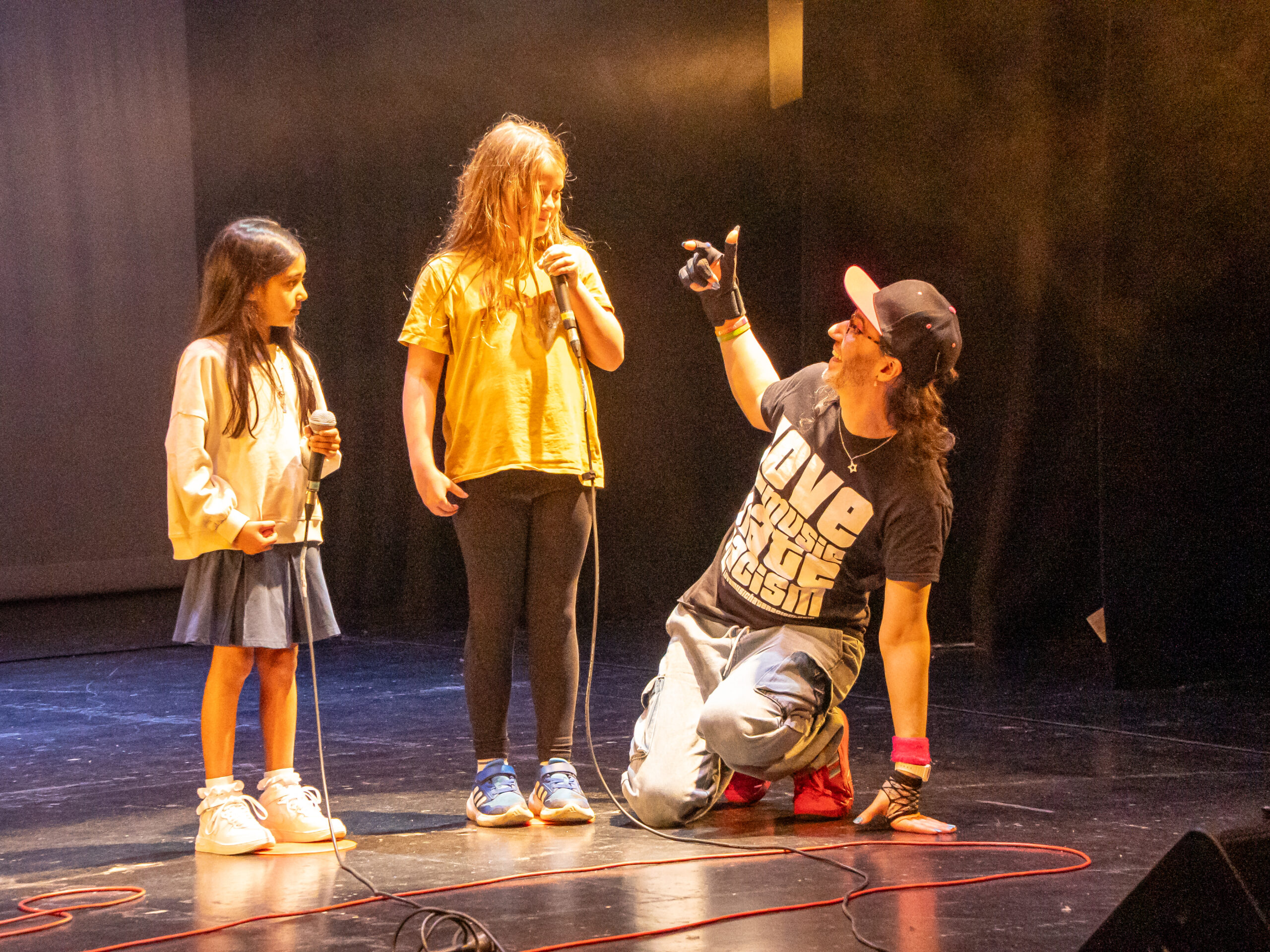 an image of SK Shlomo on stage with two children