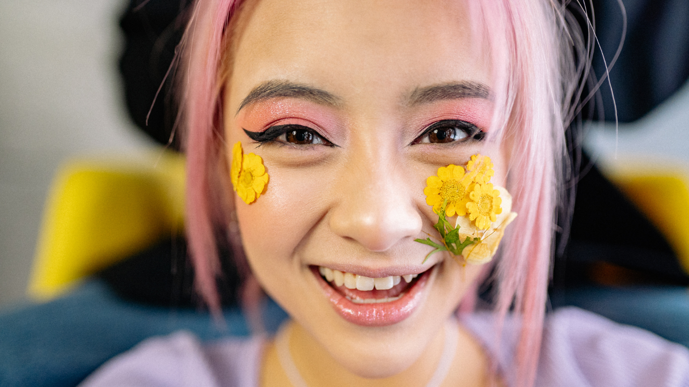 image of a young person with pink hair and flowers on their face